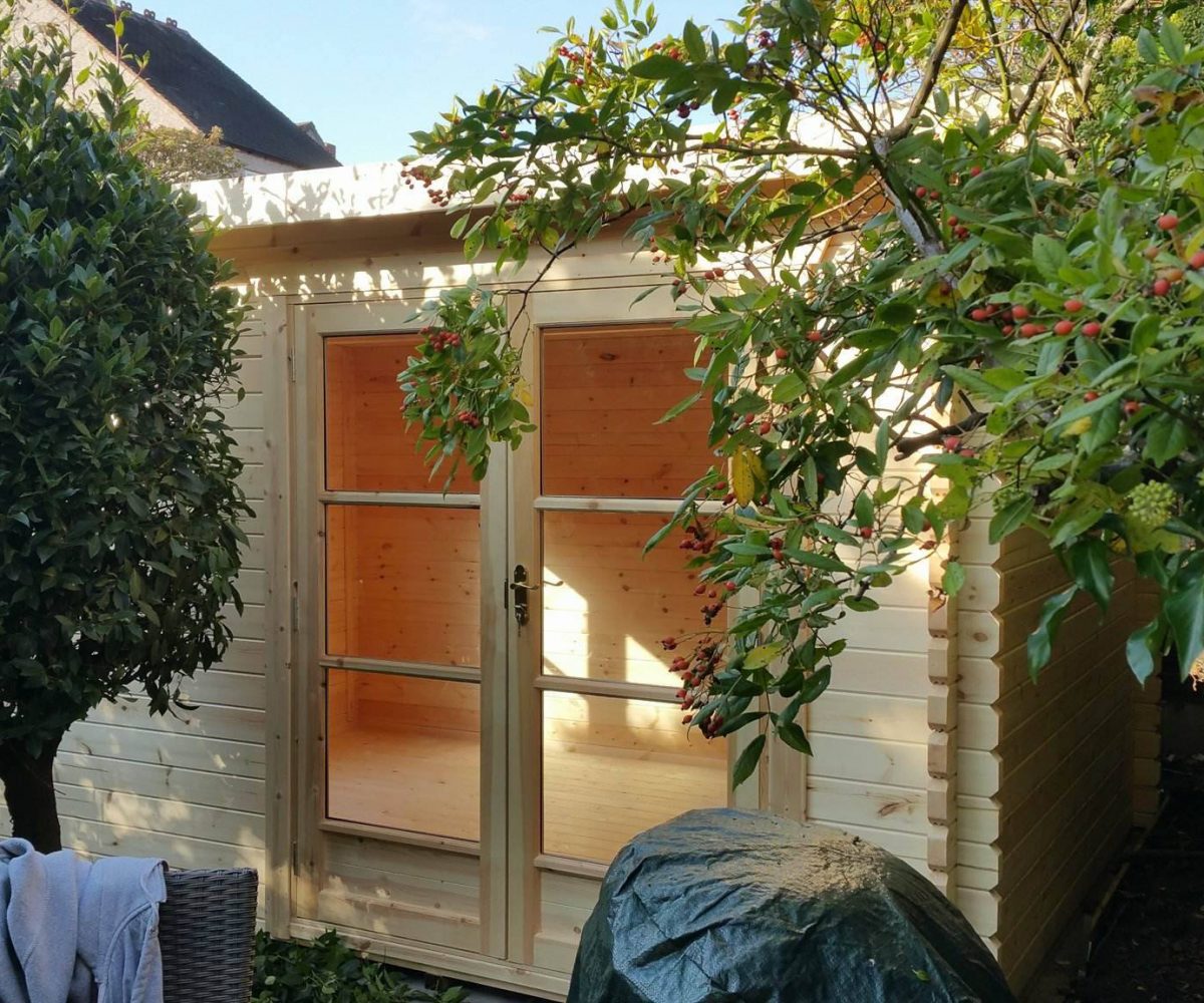 Log cabin with fully glazed double doors, in a customer garden.