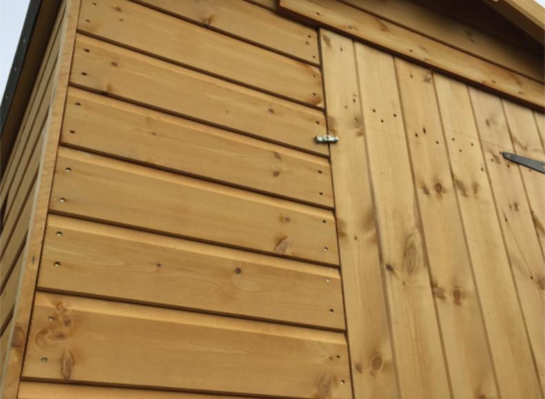 Close up of wooden garden shed with lockable single door and apex roof.
