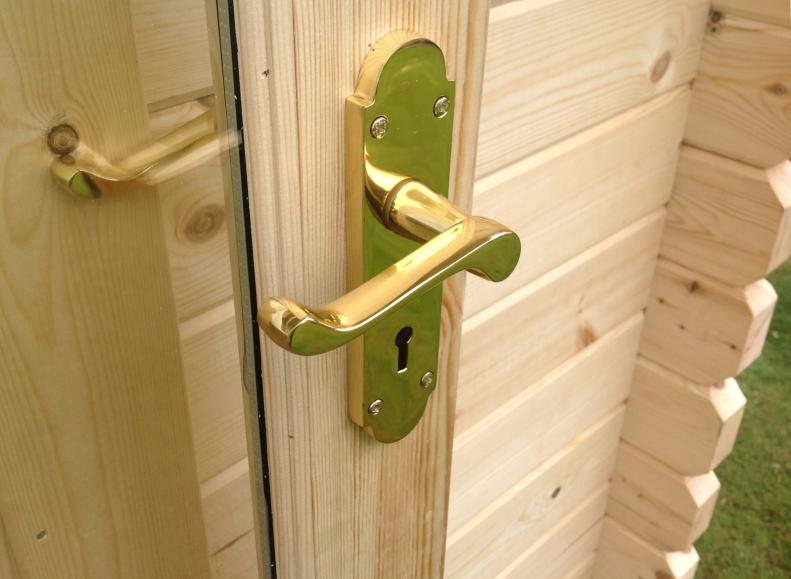 Metallic finish door handle on a log cabin door.