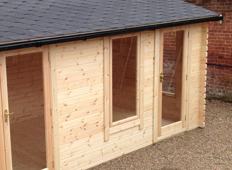 Log cabin with two fully glazed single doors, window, black guttering and apex roof with black shingles.
